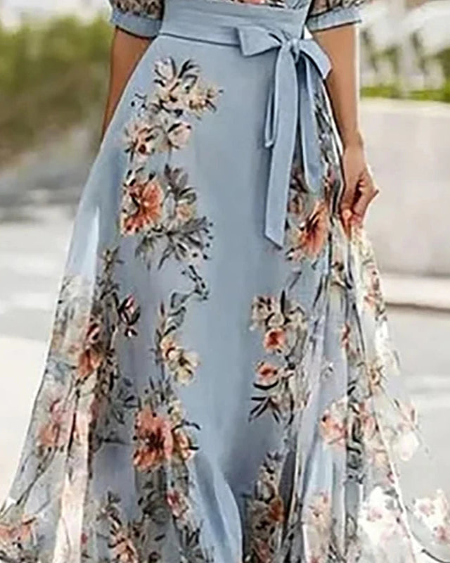 Light blue dress with floral patterns on a blurred outdoor background