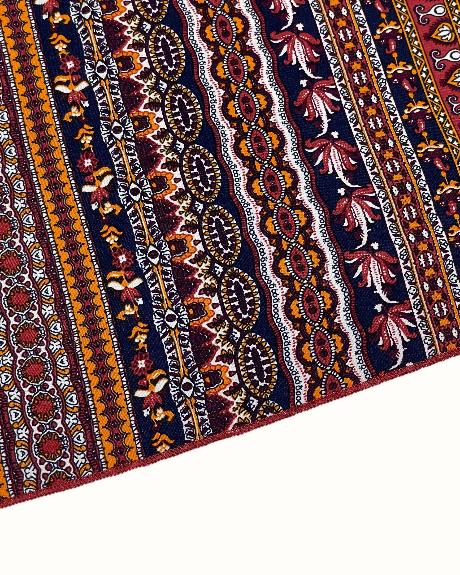 Close-up of a patterned fabric with intricate designs on a white background