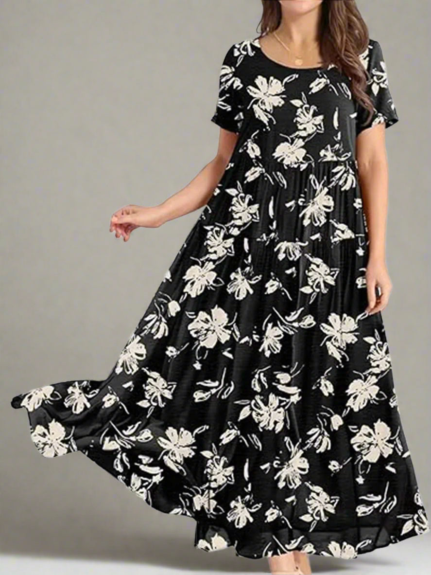 Black dress with white floral pattern worn by a model on a white background