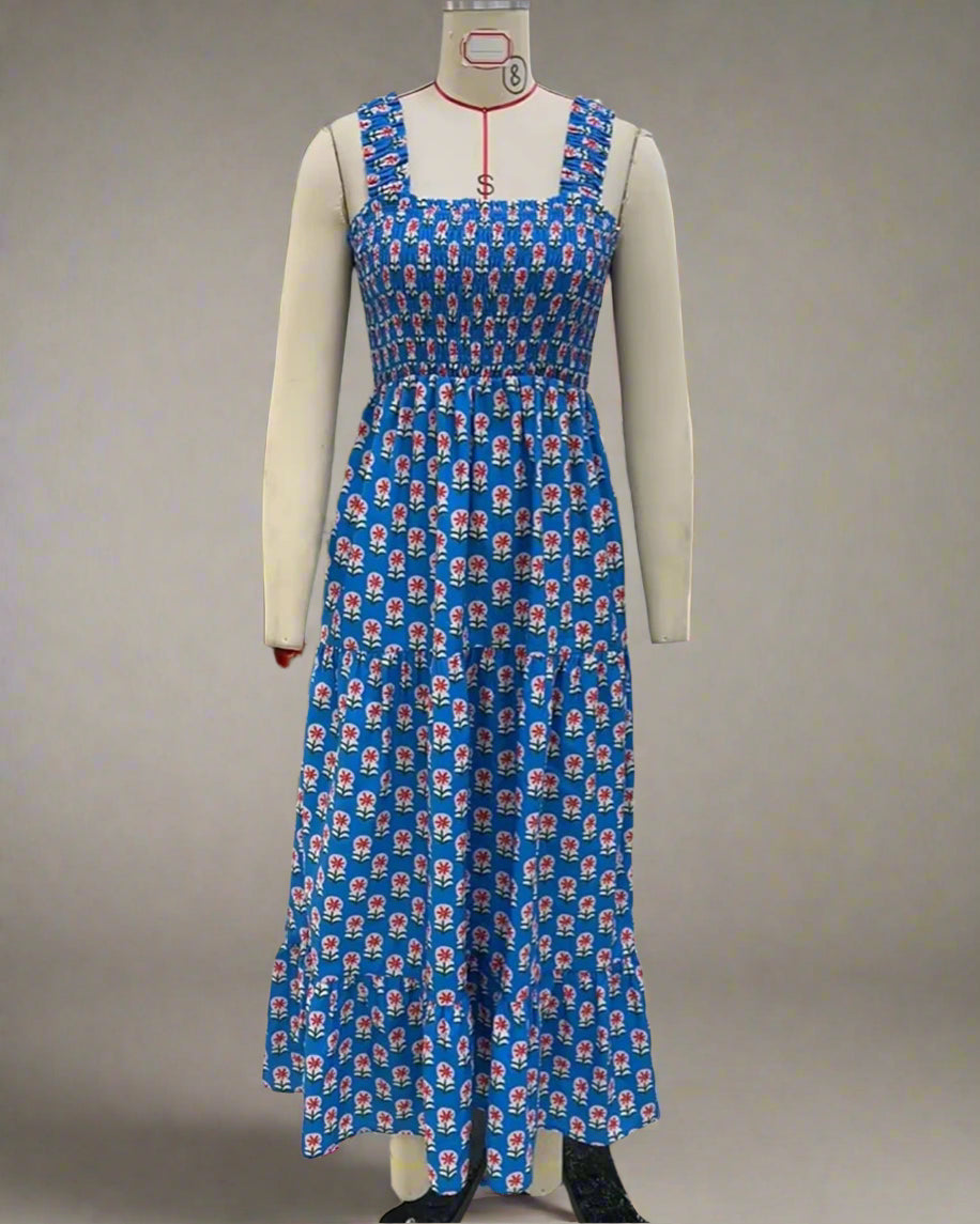 Blue floral dress on a mannequin in an indoor setting with a plant and office furniture.