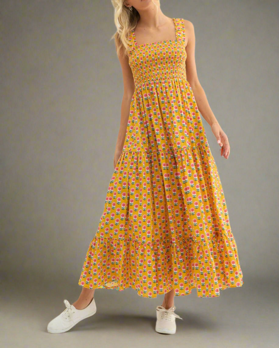 Woman wearing a yellow patterned dress on a white background