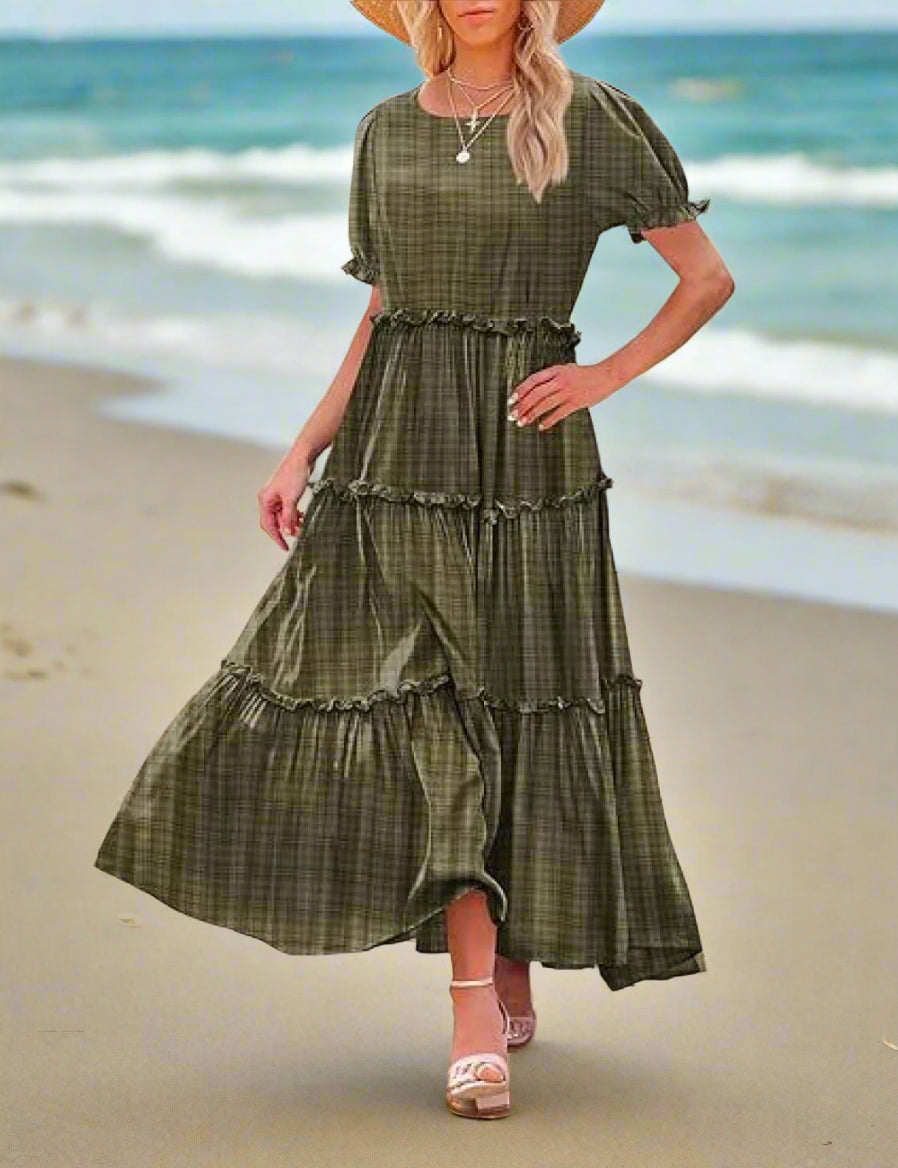 Woman wearing a green plaid dress standing outdoors.