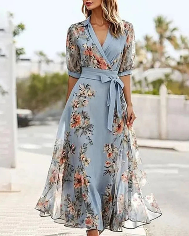 Woman wearing a light blue floral dress with a blurred outdoor background