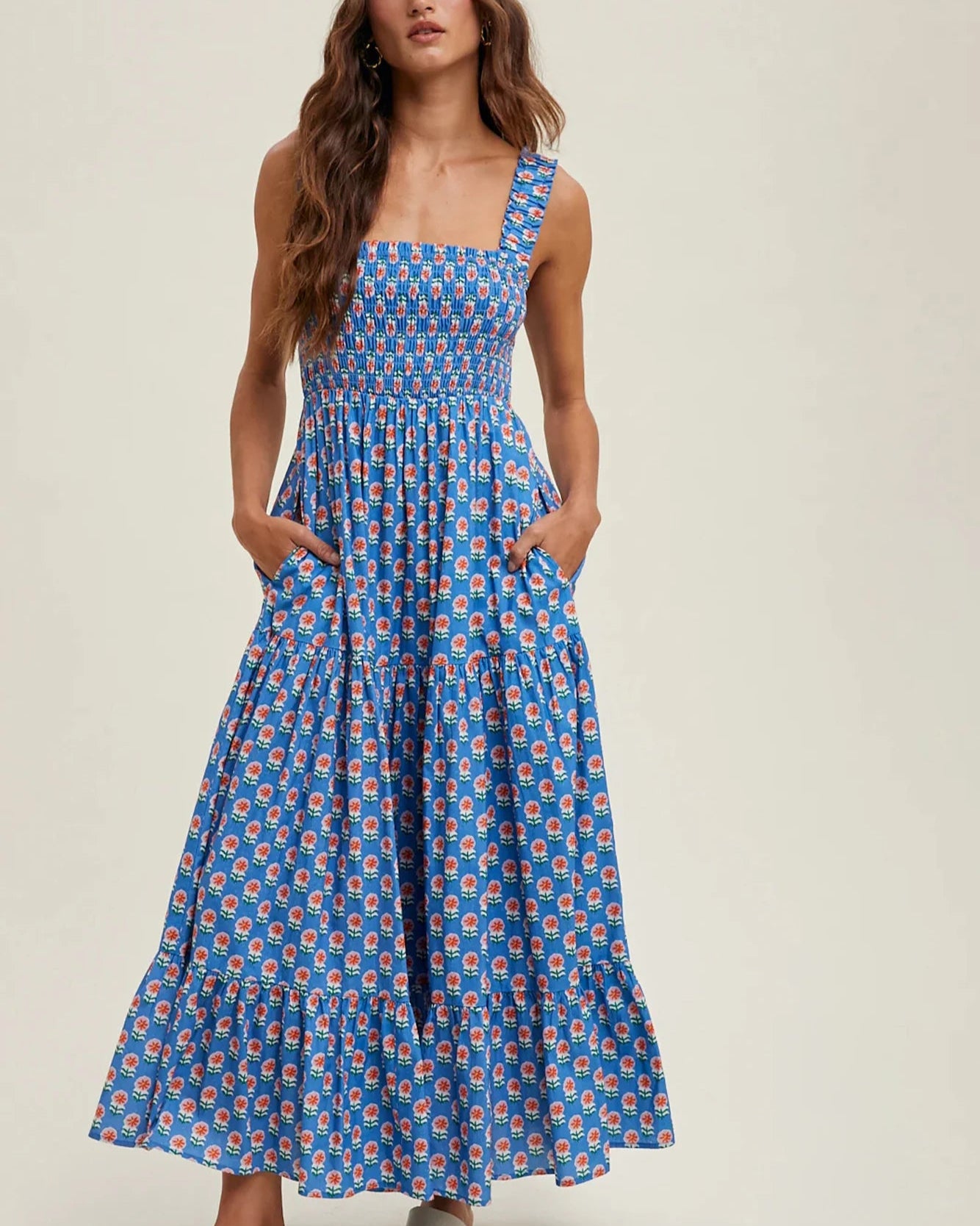 Woman wearing a blue patterned dress on a beige background