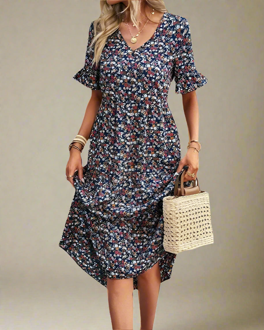 Woman wearing a floral dress holding a straw bag on a white background
