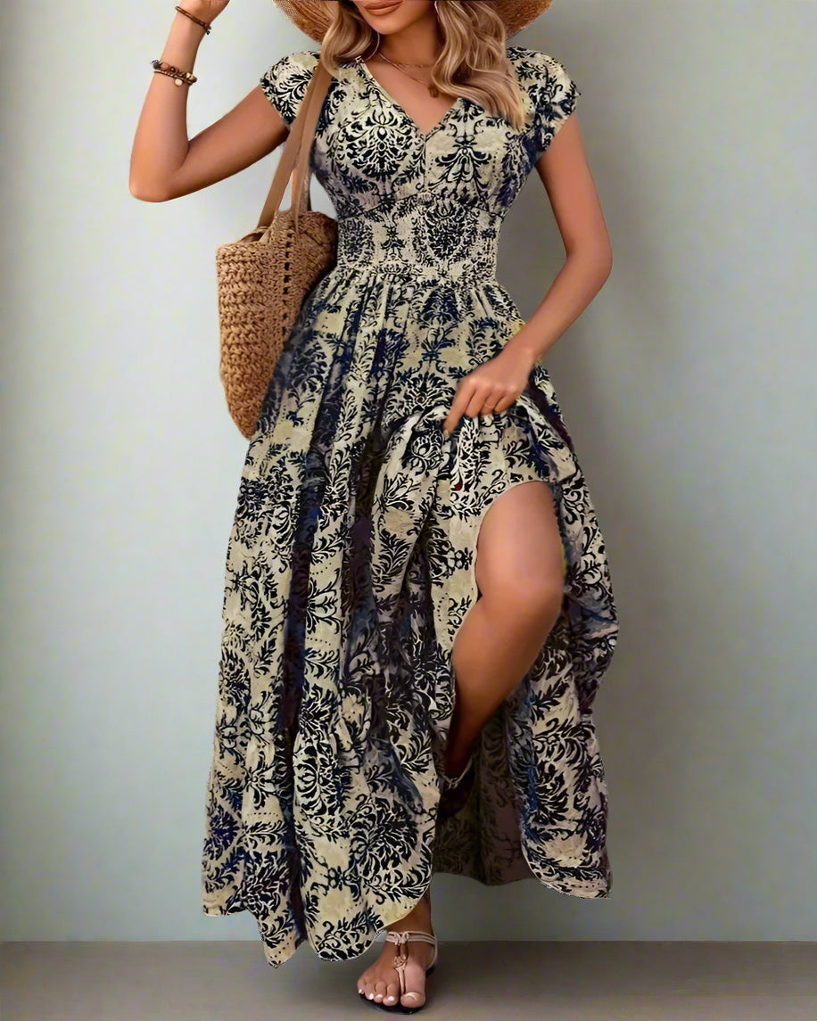Woman wearing a floral dress with a slit, standing against a textured wall.