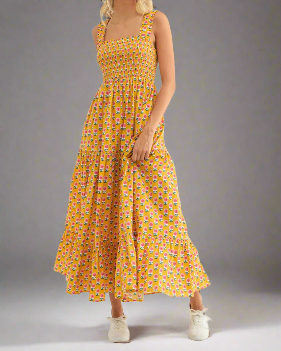 Woman wearing a yellow floral dress on a white background