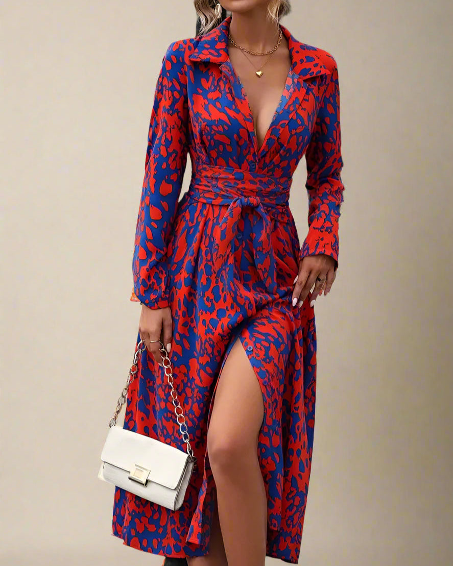 Woman wearing a red and blue patterned dress with a white handbag.