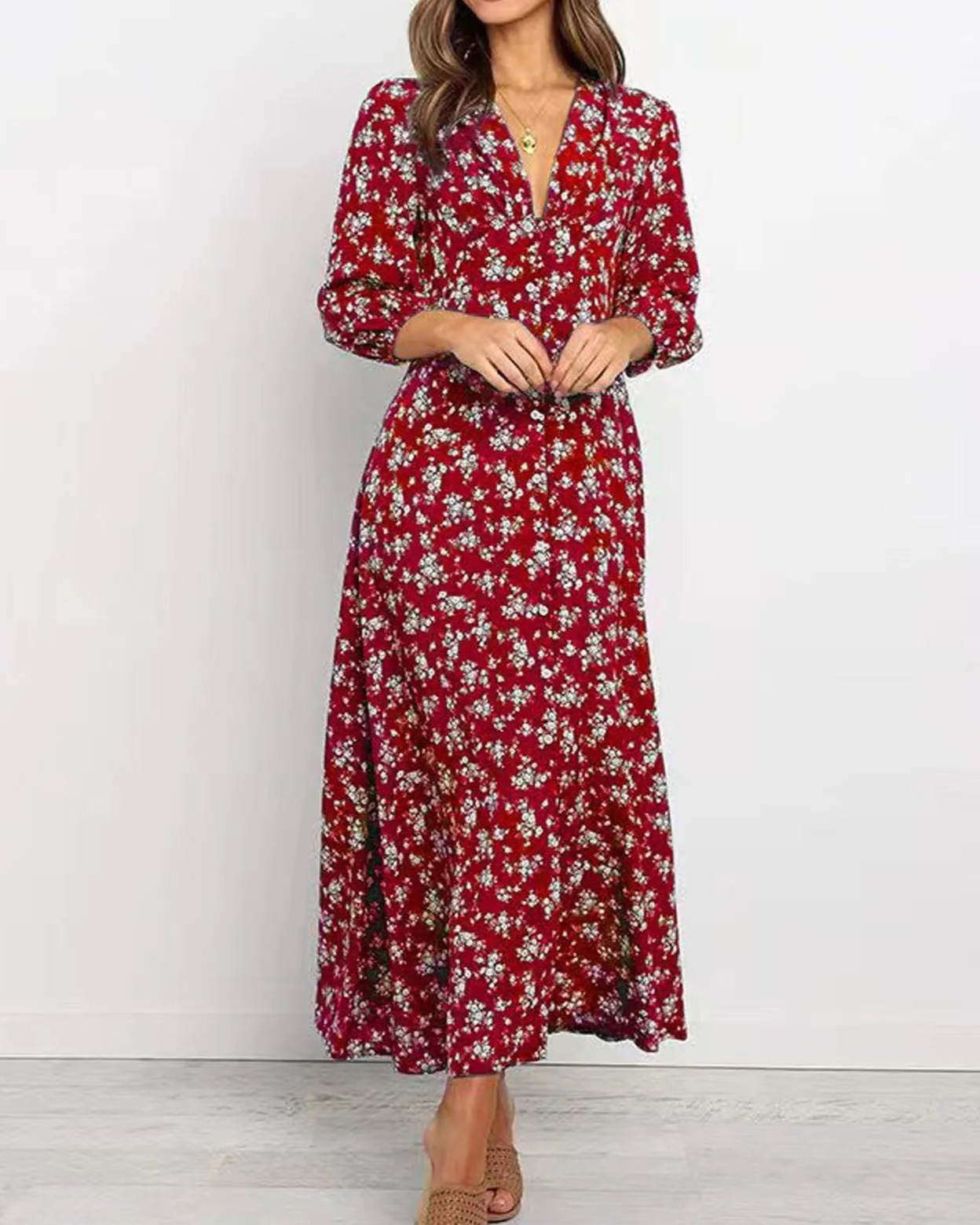 Woman wearing a red floral dress against a white background