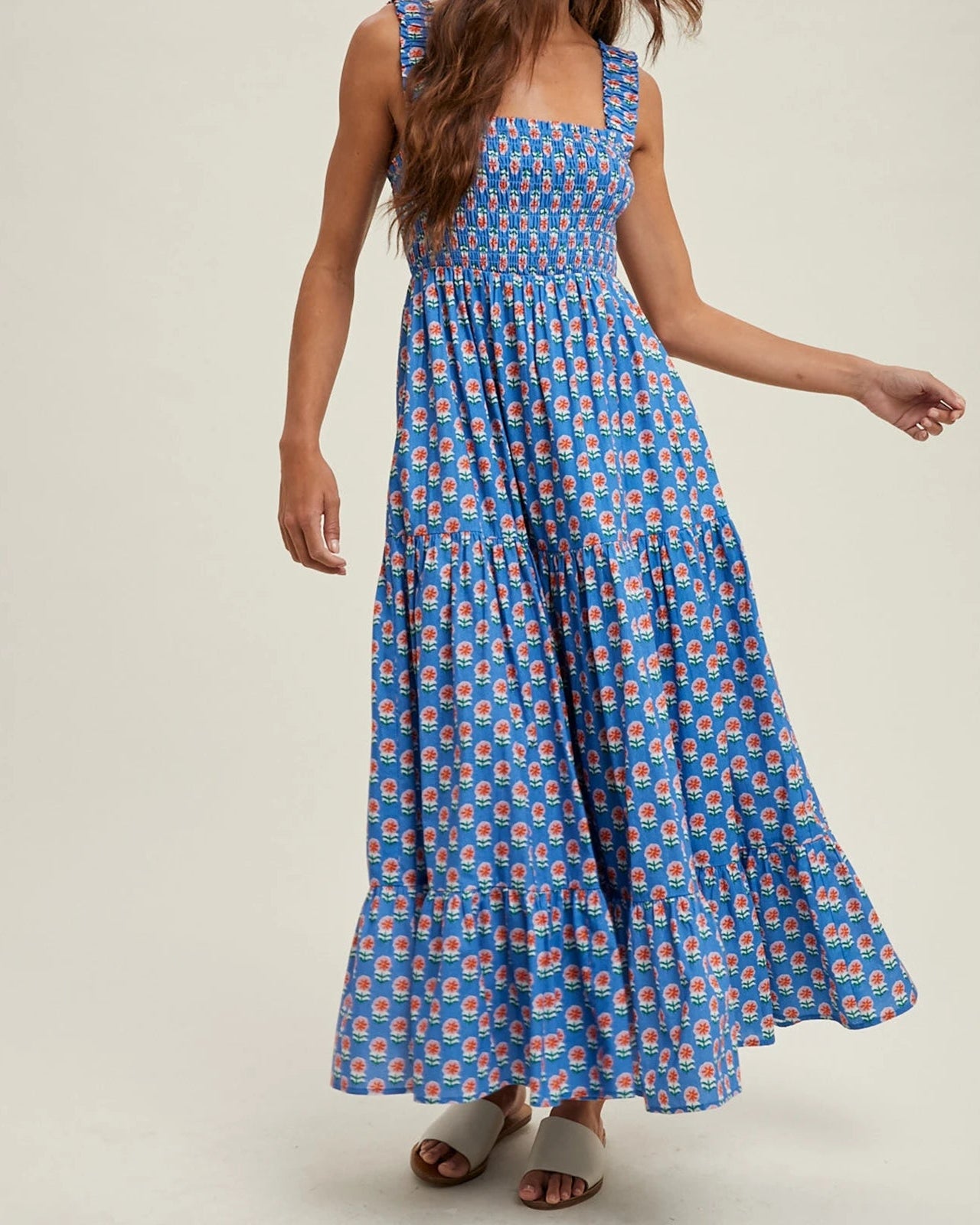 Woman wearing a blue floral dress on a plain background