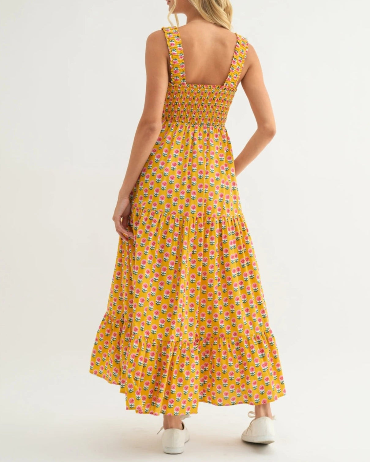 Woman wearing a yellow patterned dress on a white background