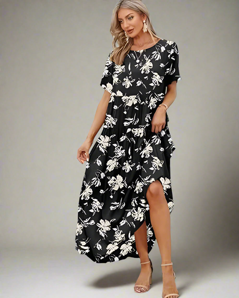 Woman in a black floral dress standing on a dock with palm trees and blue sky in the background