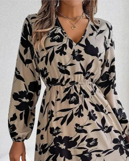 Woman wearing a floral dress holding a straw bag indoors.