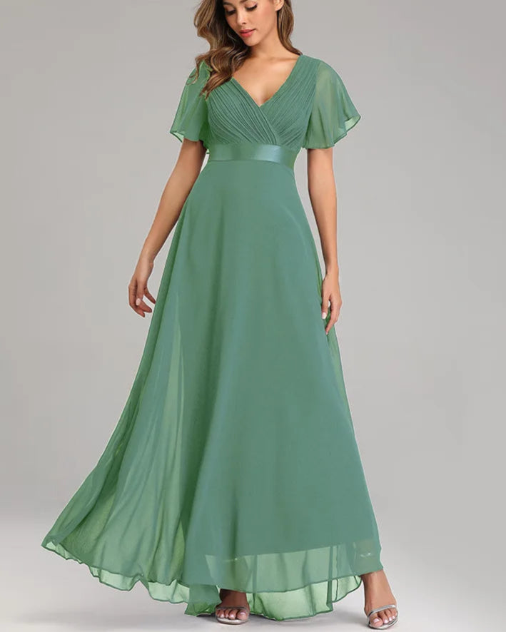 Woman wearing a green evening gown on a gray background