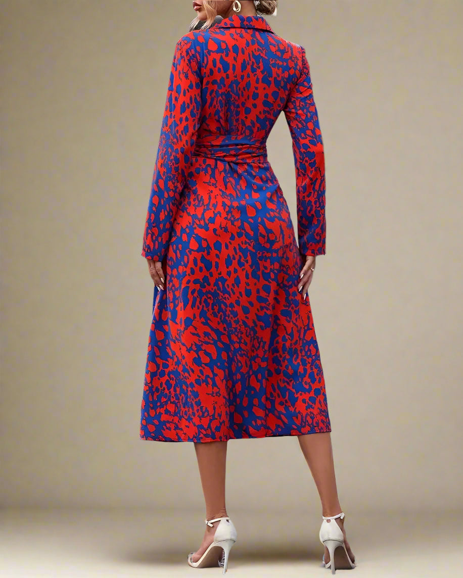 Woman wearing a red and blue patterned dress on a city street.